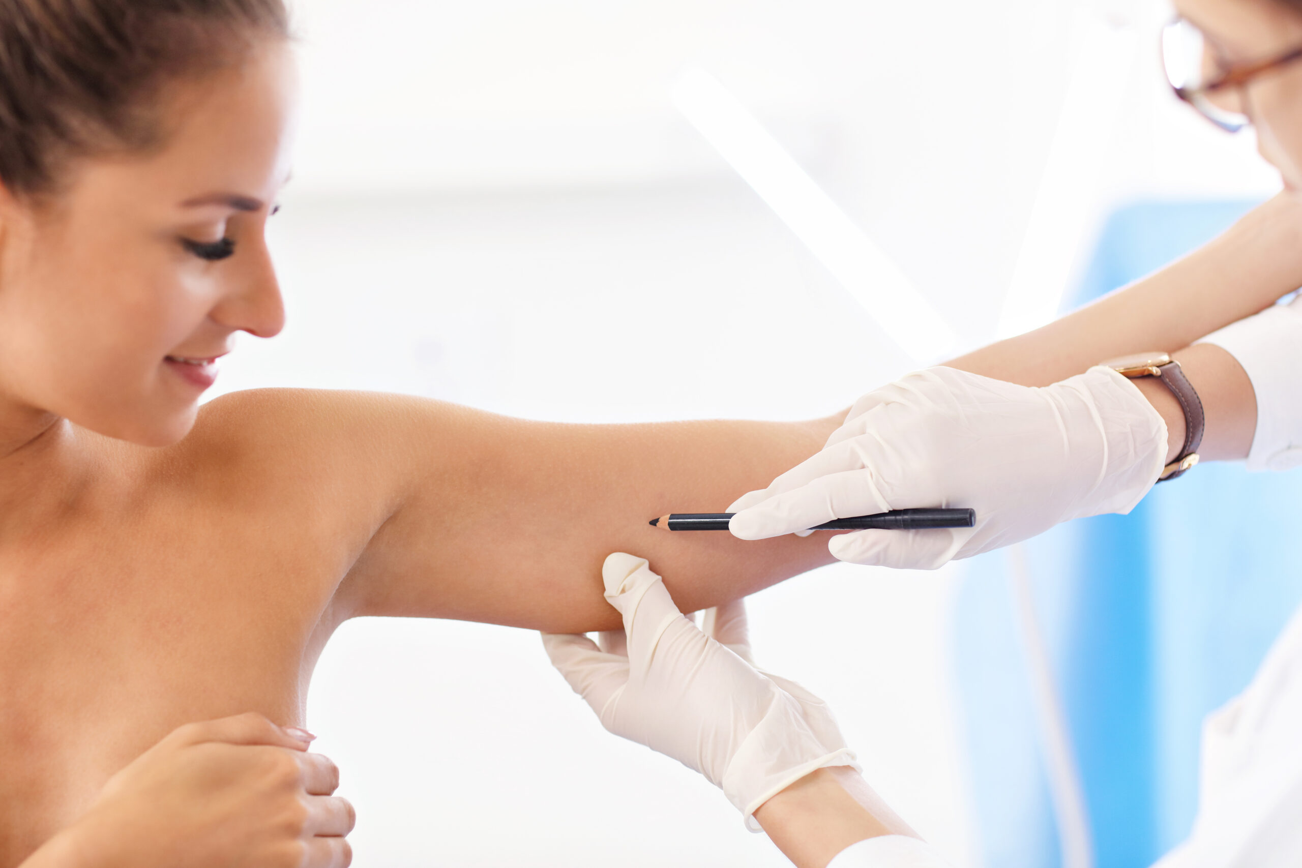 Plastic surgeon making marks on patient's body